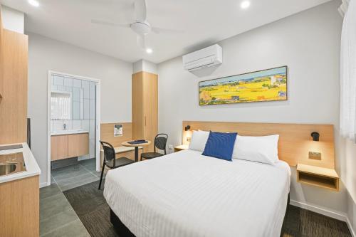 a hotel room with a bed and a desk at Avenue WEST Studio Units in Toowoomba