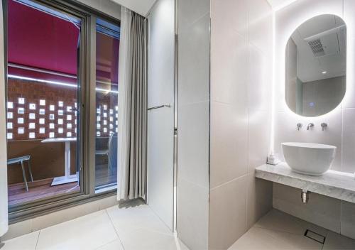 a bathroom with a sink and a glass shower at 부산 대연동 뮤트호텔 in Kwangan-dong