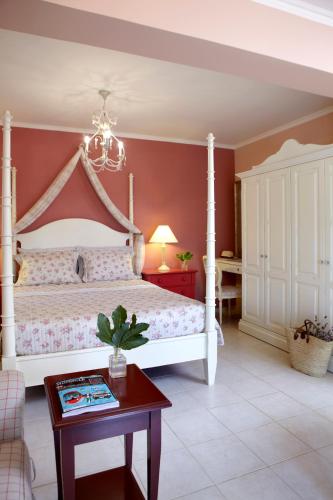 a bedroom with a white bed and a table at Avra Private Suites in Lassi