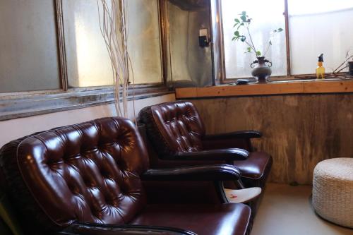 two leather chairs in a room with a window at 海好きな大人の隠れ家下田ハウス in Shimoda