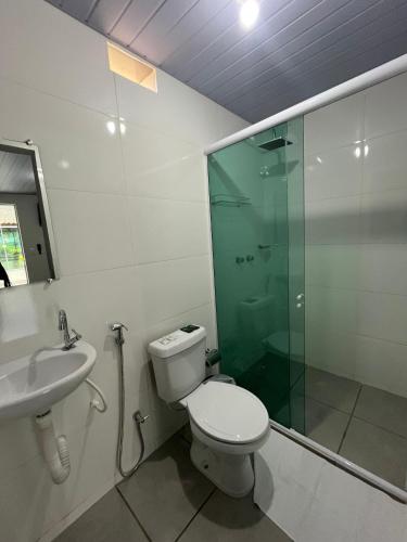 a bathroom with a toilet and a shower and a sink at suítes Arco-íris in Uberlândia
