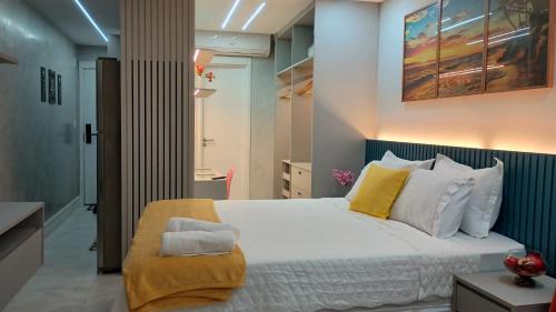 a bedroom with a bed with yellow and white pillows at Studio Luxuoso frente Mar in Salvador