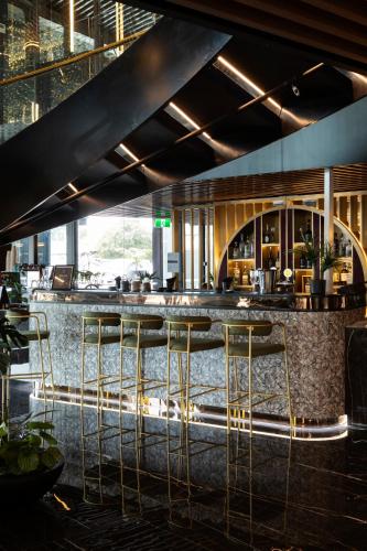a bar in a restaurant with stools at a counter at SOHO Hotel Auckland in Auckland