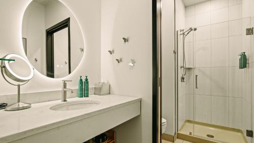 a bathroom with a sink and a mirror and a shower at Violet Inn, Lounge & Spa in Two Rivers