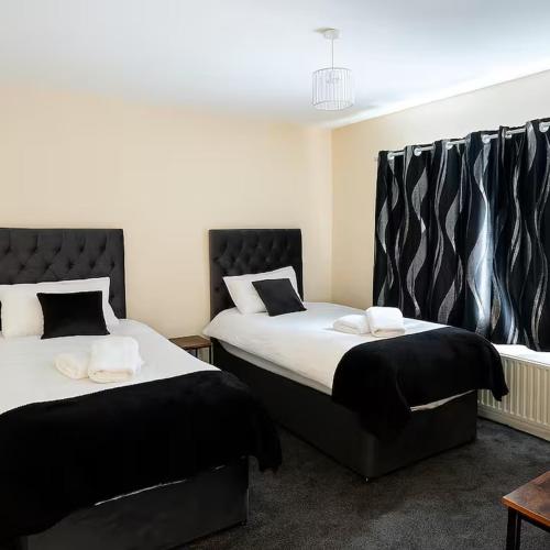two beds sitting next to each other in a room at Nayla House Cozy 4BR with Garden & Parking in Moffat