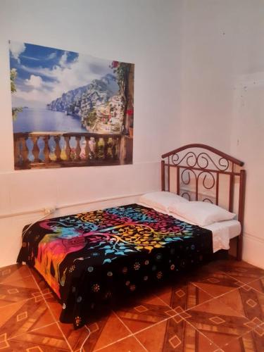 a bed in a room with a painting on the wall at Amalfi's Place in Pimentel