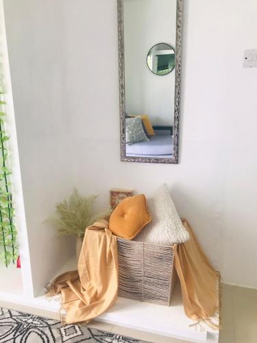 a mirror on a wall above a shelf with a basket at Casa Bonita GLAM in Castries