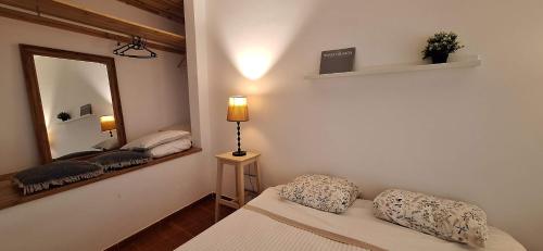 a room with a mirror and a couch and a lamp at Daniel in Lagoa
