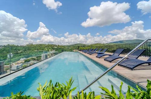 a swimming pool with lounge chairs on a balcony at ON Smart Lofts - 3 min a pé da Oktoberfest com cama Queen in Blumenau