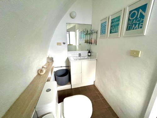 a small bathroom with a toilet and a sink at Dome by the sea in Trinity Beach