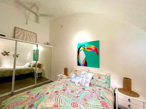 a bedroom with a bed and a painting on the wall at Dome by the sea in Trinity Beach