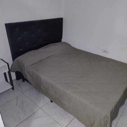 a small bed in a corner of a room at Hospedaje El Colibri in Ezeiza