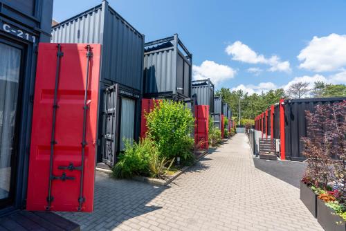 a row of red doors on a building at HOTEL R9 Kujukuri "ex Casual Resort COFF Ichinomiya" in Ichinomiya