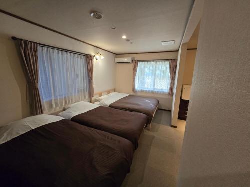 a bedroom with two beds and a window at Ikoi in Nikko