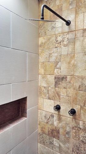 a shower in a bathroom with a stone wall at Cerro Escondido in Chiapa de Corzo