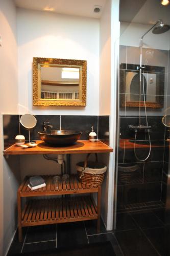 y baño con lavabo y espejo. en Chambres d'Hôtes des Demoiselles, en Ville-Saint-Jacques