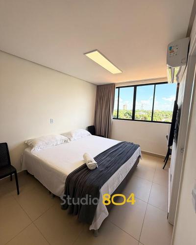 a bedroom with a bed and a large window at Studio Connect Life in Teresina