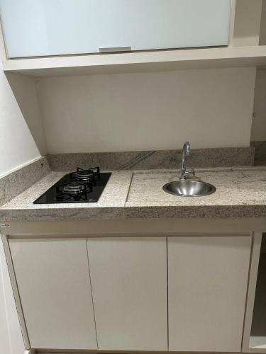 eine Küchenarbeitsplatte mit Spüle und Herd in der Unterkunft Flat em Palmas no Vivence hotel in Palmas