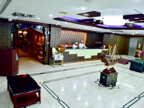 a lobby with a table and a bar in a building at Al Bahjah Hotel in Seeb