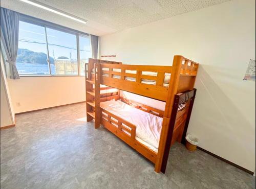 two bunk beds in a room with a large window at Magokoro House 203 in Nishiizu