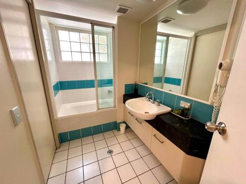 a bathroom with a sink and a mirror at The Beachfront in Trinity Beach