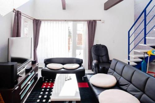 a living room with a couch and a chair at STAY IN TOYOOKA in Asahikawa