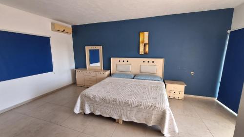 a blue bedroom with a bed and a blue wall at Villa Casa blanca Con Alberca privada in Acapulco