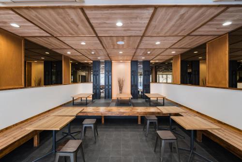 a large conference room with wooden tables and chairs at OKINI - Doyanen Hotels in Osaka