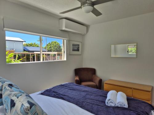 a bedroom with a bed and a window and a chair at Noosa Sun - On the Noosa River in Noosaville