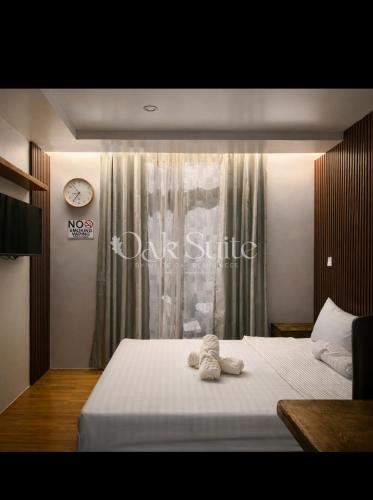 a bedroom with a bed with a stuffed animal on it at Oak Suite in Baguio