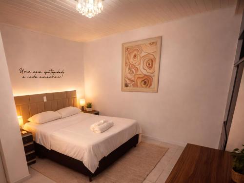a bedroom with a bed and a picture on the wall at Studio Central - Climatizado - Prático in Erval dʼOeste