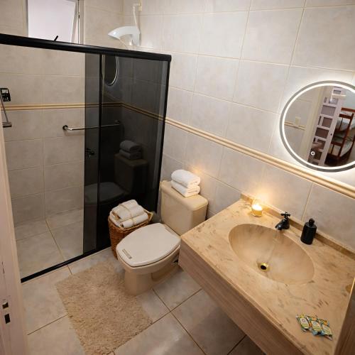 a bathroom with a toilet and a sink and a shower at Studio Central - Climatizado - Prático in Erval dʼOeste