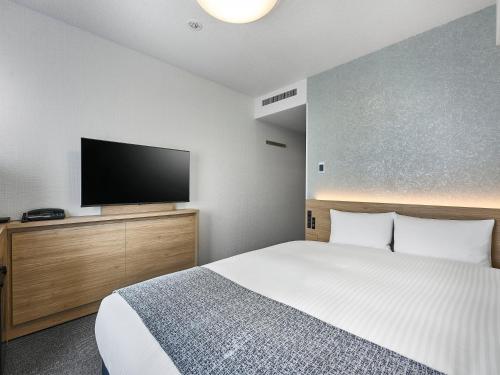 a bedroom with a bed and a flat screen tv at Daiwa Roynet Hotel Tokyo Akabane in Tokyo