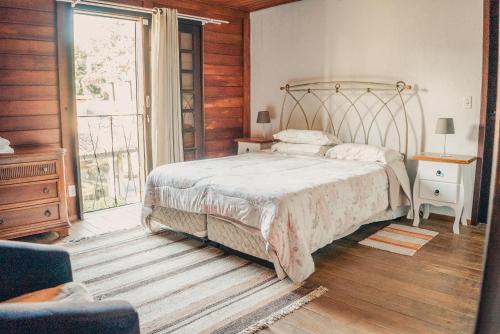 a bedroom with a bed and a large window at Chacara da Dinda in Piraquara