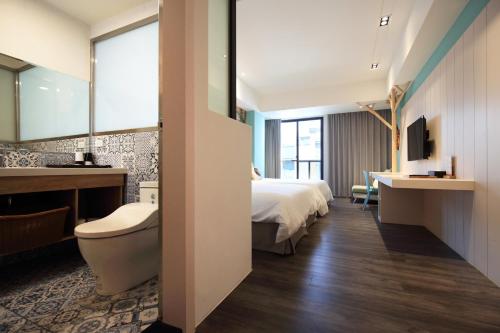 a hotel room with a bed and a bathroom at Hai Sheng Wei B&B in Dahan