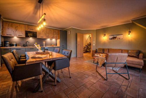 a kitchen and living room with a table and chairs at Witter Barg - Ferienwohnung mit Sauna in Koserow
