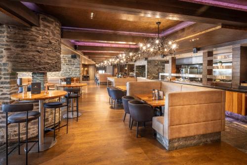 a restaurant with tables and chairs and a bar at Hilton Queenstown Resort & Spa in Queenstown