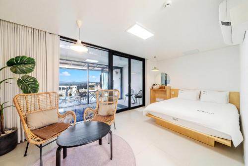 a bedroom with a bed and a table and chairs at Gyeongju heybreeze Pool Villa in Gyeongju
