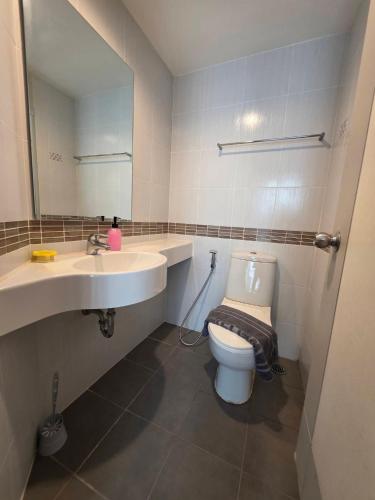 a bathroom with a toilet and a sink and a mirror at Modern Grey in Udon Thani