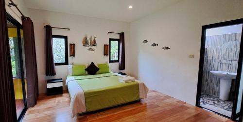 a bedroom with a green bed and a sink at Nubdao Resort&Restaurant in Nong Prue