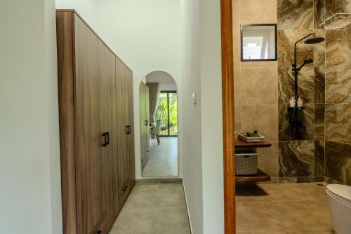 a bathroom with a tub and a toilet and a hallway at Palm Rose Villa in Hinkong