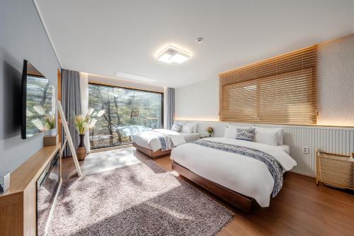 a bedroom with two beds and a large window at Wonju Healing Forest in Wonju