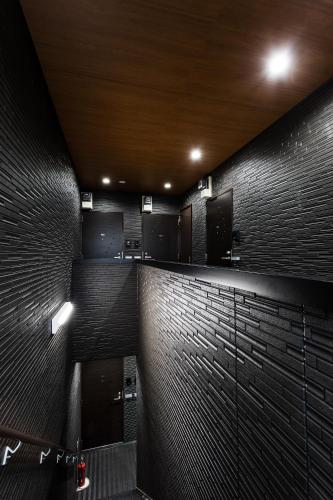 a bathroom with black brick walls and a sink at New Open! SunLight 岸里 in Osaka