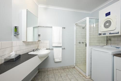 a bathroom with a sink and a washing machine at Unit 9 Bellevue in Lakes Entrance