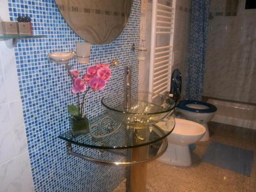 a bathroom with a glass table with flowers on it at B&B Ametista in Trieste