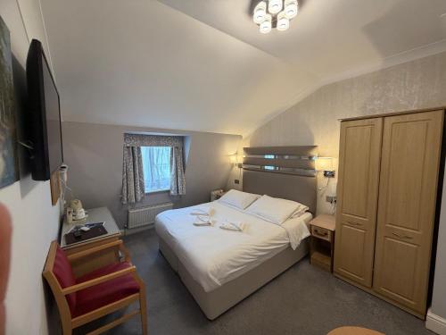 a small bedroom with a bed and a chair at Admiral Hotel at Park Avenue in London