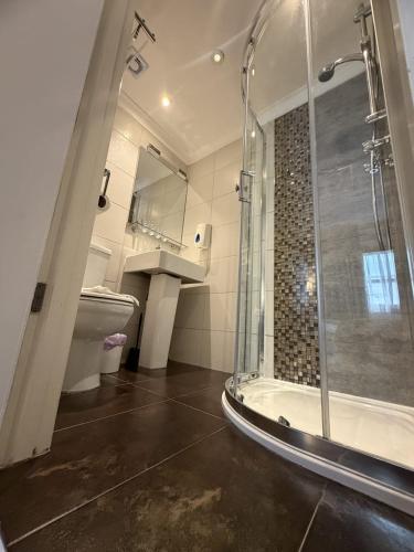 a bathroom with a shower and a toilet and a sink at Admiral Hotel at Park Avenue in London