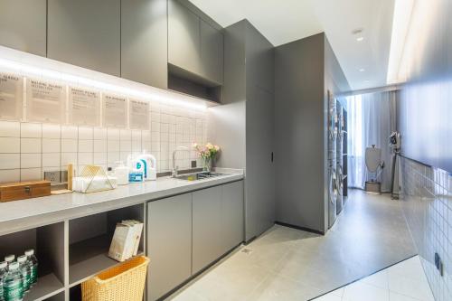 a kitchen with white cabinets and a counter top at Atour Hotel Hefei Yaohai Heping Road in Hefei