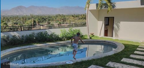a boy standing in a swimming pool with a frisbee at Casa Vista Animas San Jose del Cabo in San José del Cabo
