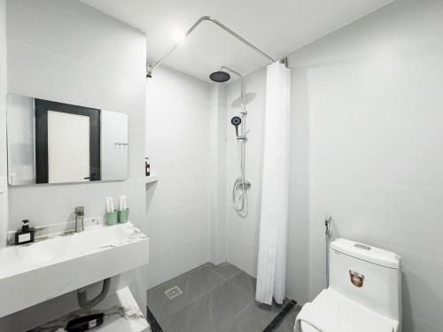 a white bathroom with a toilet and a sink at Louis Home in Danang